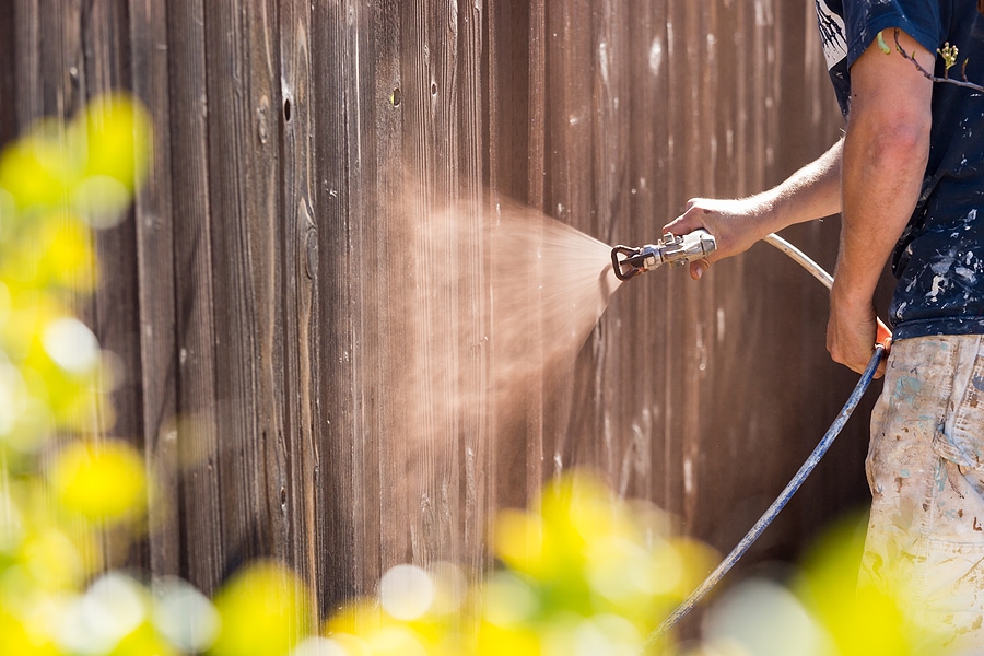 Spray staining wooden fence